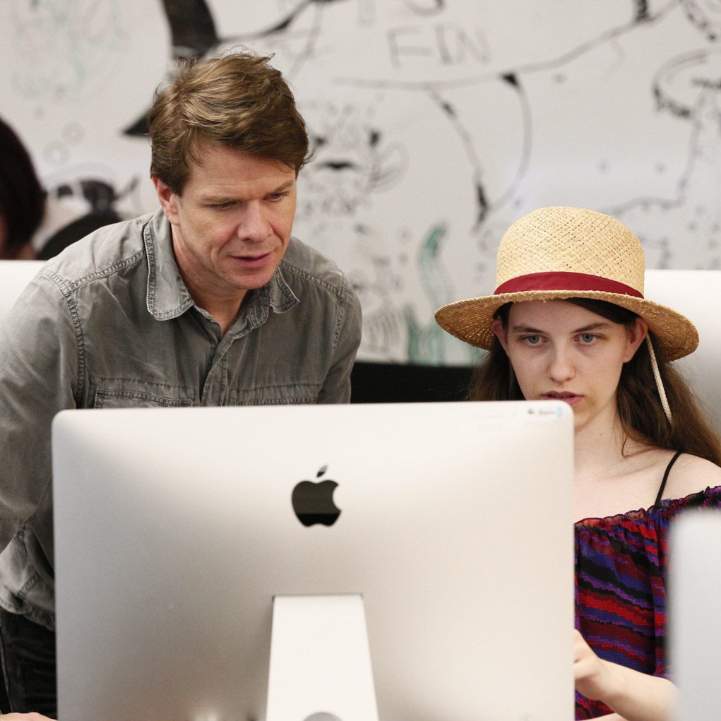 Instructor assisting student on computer