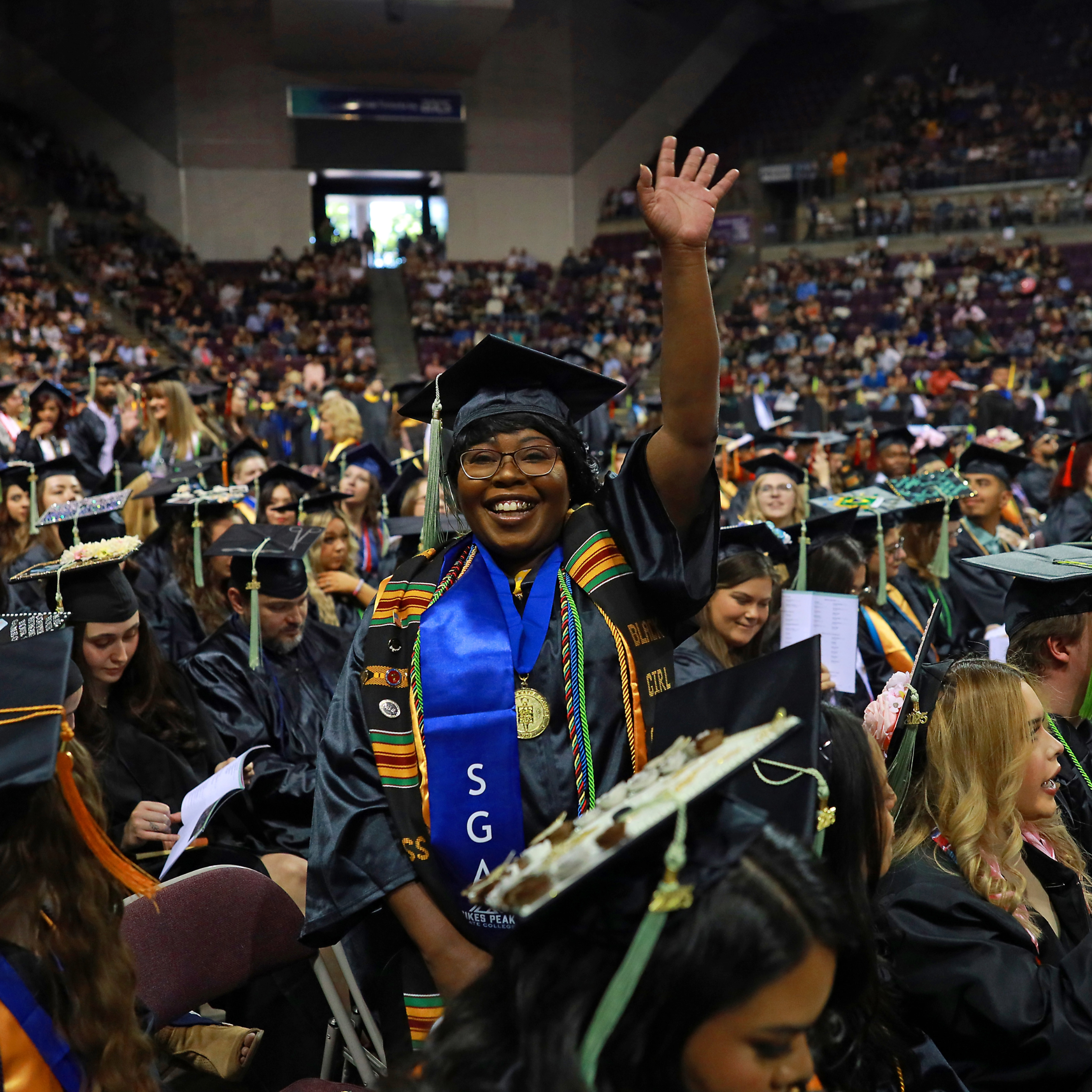 Graduate waving to family during ceremony 