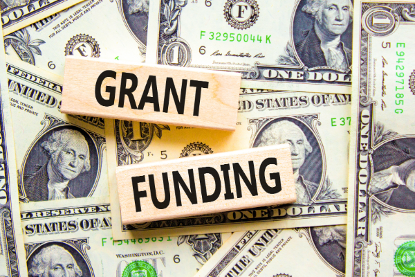 "grant funding" on wooden blocks on top of U.S. currency